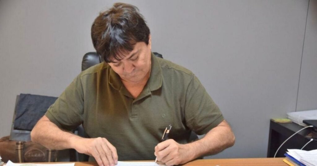 Léo Cunha escrevendo em uma mesa.